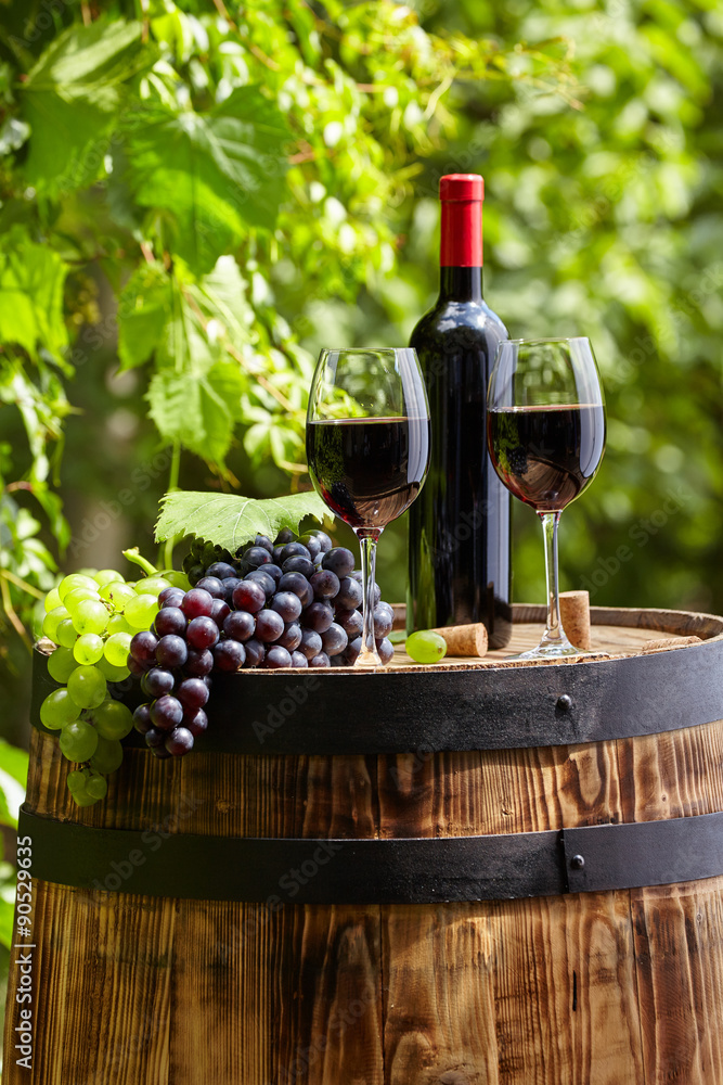 Old wooden barrel with glass of red wine.
