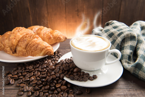 Fototapeta Naklejka Na Ścianę i Meble -  Breakfast coffee cup and croissant on wooden background