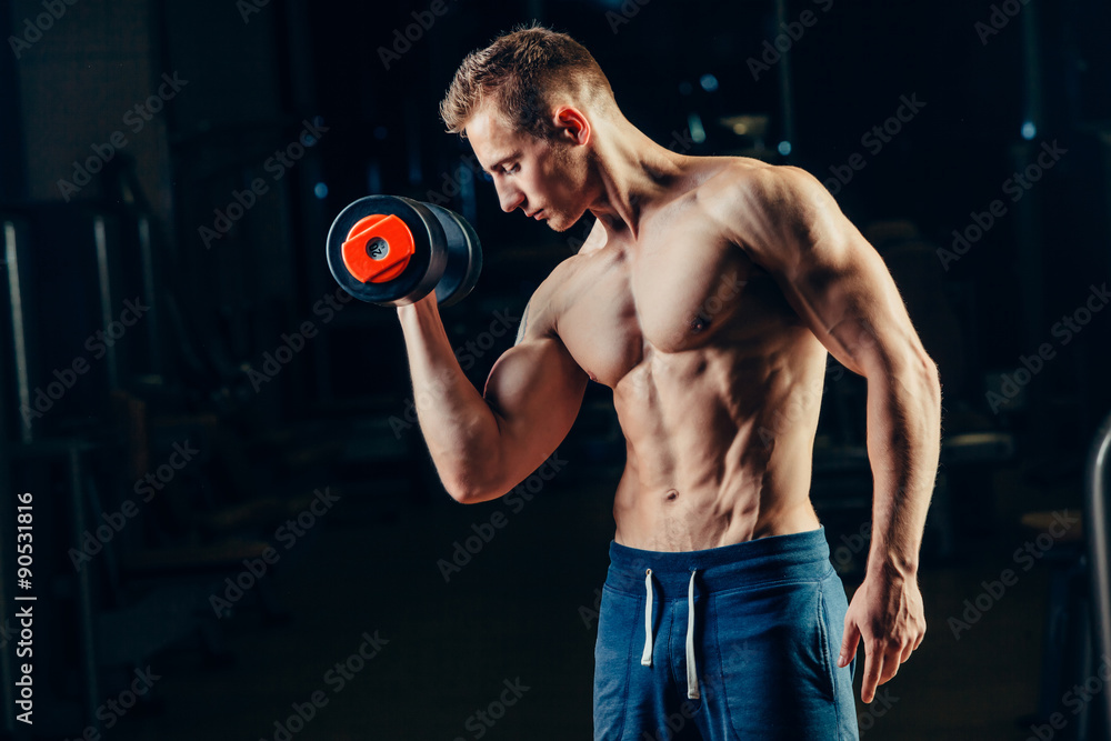 Athlete muscular bodybuilder training back with dumbbell  in the