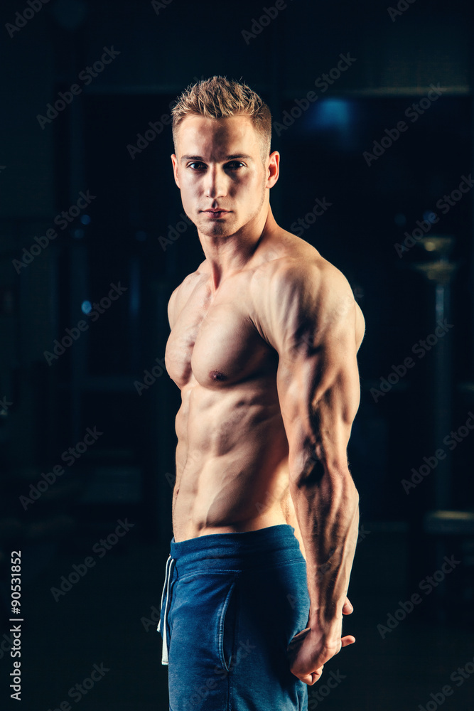 Fototapeta premium Silhouette of a athlete. Confident young fitness man with strong