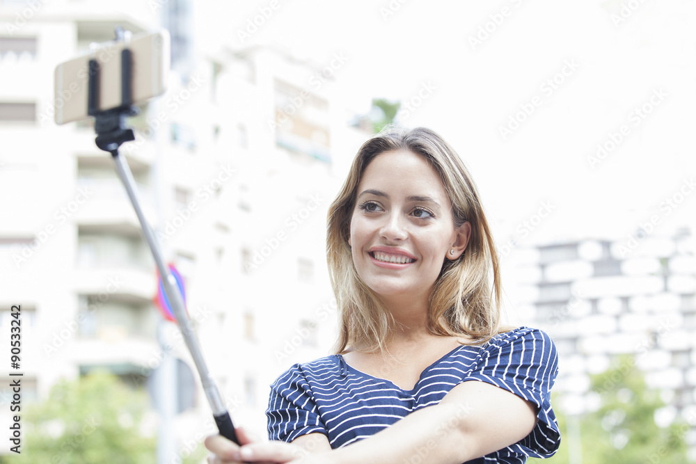 Young beautiful girl taking selfie stick picture happy on sunny day Stock  Photo | Adobe Stock