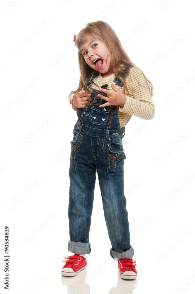 cute little girl wearing jeans overall posing in studio and smil cute little girl wearing jeans overall posing in studio and smil
