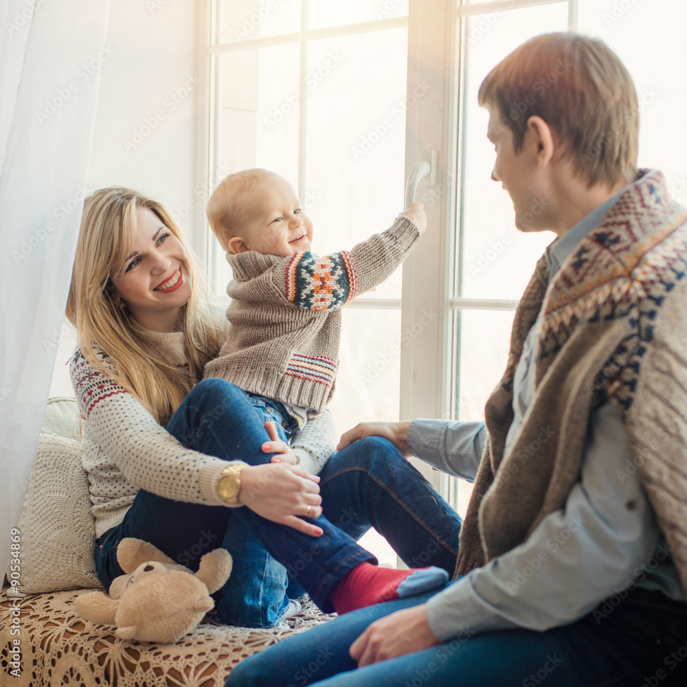 Happy family sitting in front of window in winter. Stock Photo | Adobe ...