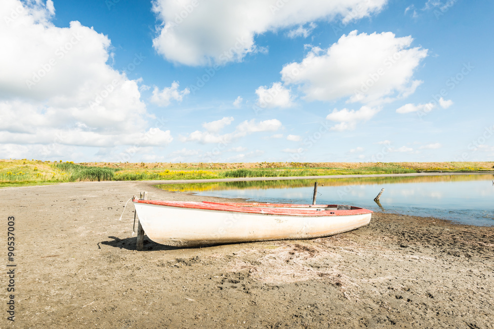 White boat on the banks of a natural pond White boat on the banks of a natural pond