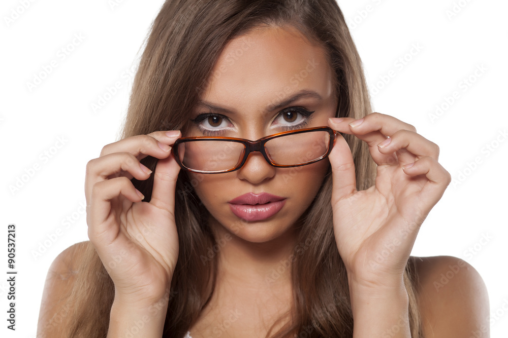 serious beautiful girl with glasses posing on a white background