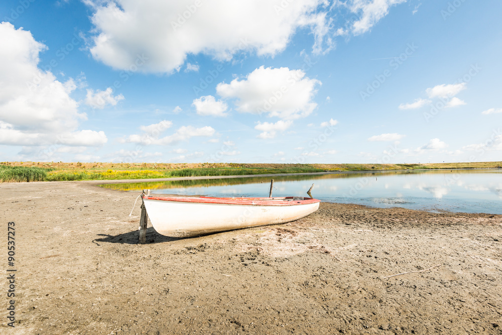 White boat on the banks of a natural pond