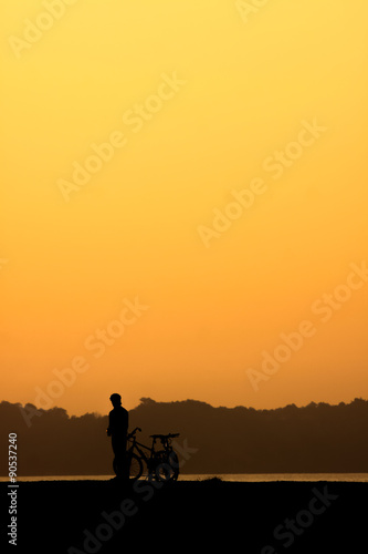 Silhouette of cyclist at sunset. © pojvistaimage
