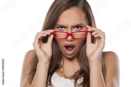 Fotografija surprised beautiful girl with glasses posing on white