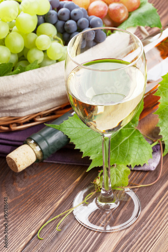 White wine glass, bottle and grapes