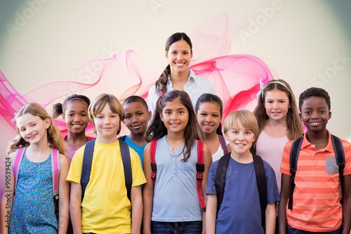 Composite image of cute pupils smiling at camera in the hall 