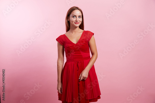 the nice girl in a red dress on a pink background