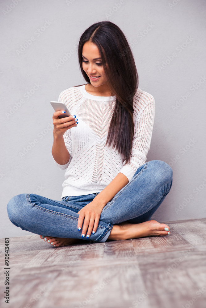Woman sitting on the floor and using smartphon Woman sitting on the floor and using smartphon