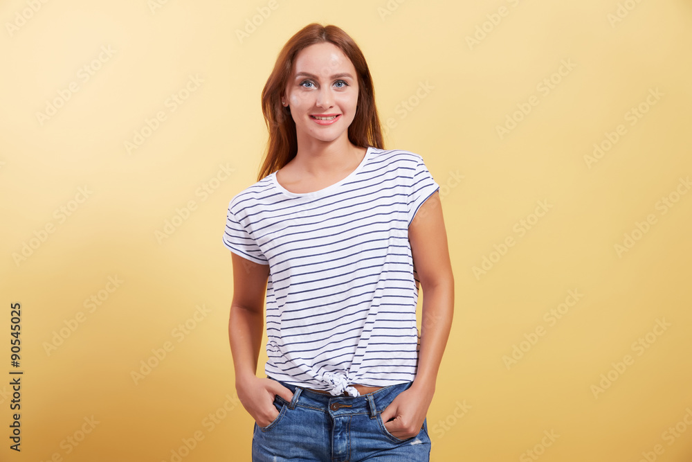 the red-haired beautiful young girl smiles on a yellow backgroun the red-haired beautiful young girl smiles on a yellow backgroun