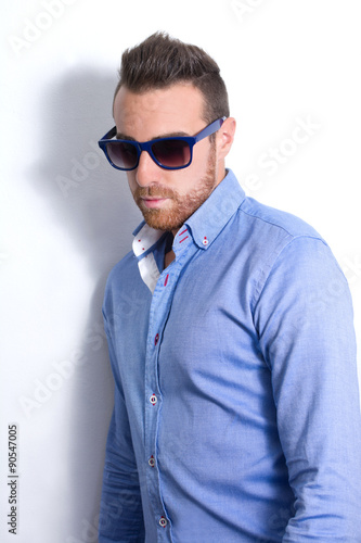 Young man posing as a model. Shadow in the wall