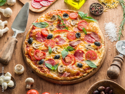 Pizza with mushrooms, salami and tomatoes.