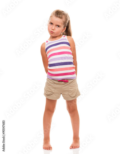 cute little girl standing on white holding hands behind back