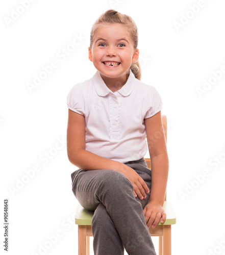 little girl sitting on a chair and smiling