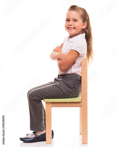 little girl sitting on a chair and smiling