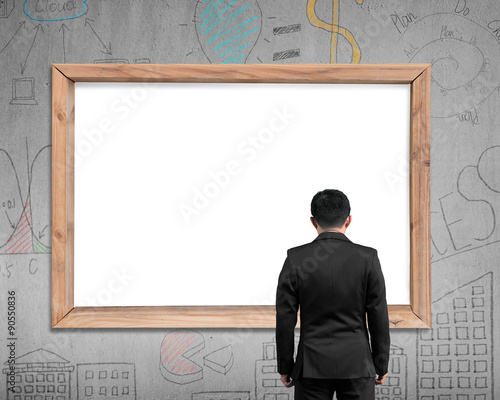 Businessman looking at wooden frame with blank white view