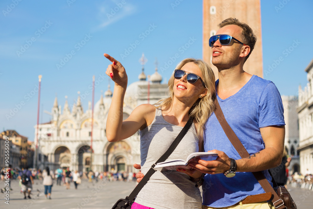 Fototapeta premium Couple reading tourist guide and sightseeing in Venice