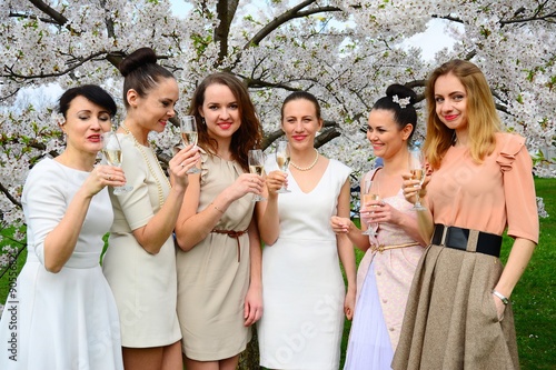 Obraz na płótnie Girls with champagne celebrating in sakura's garden. w salonie