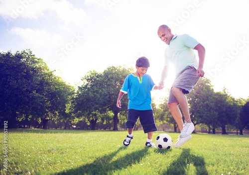 Little boy playing soccer with his father Concept