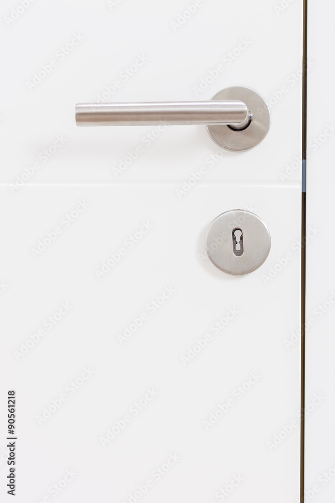 Gray metal handle on a white door Gray metal handle on a white door