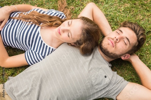 Cute couple resting in the grass in the park photo