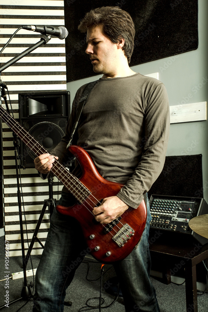 Obraz premium Rock singer playing bass in the rehearsal Studio