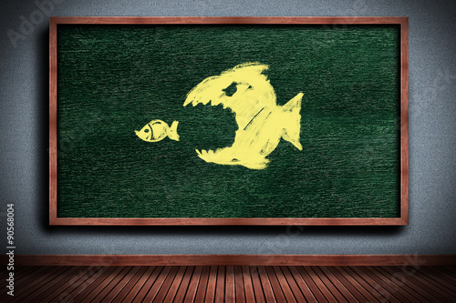 Businesswoman drawing The big fish eats the small fish on chalkboard