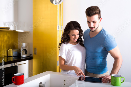 Young couple using a Tablet PC in the kitchen at home