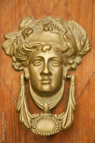 Greek Goddess knocking on the wooden door.