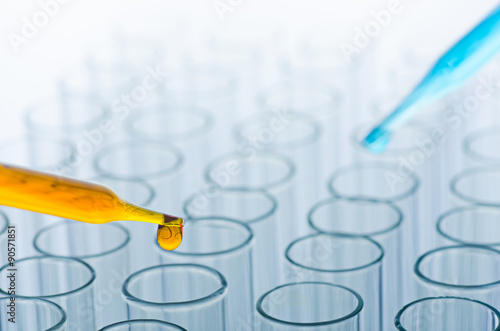 science laboratory pipette with drop on test tube background , l