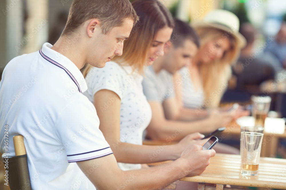 Group of teenagers sitting in a cafe spanding time with (virtual) friends Group of teenagers sitting in a cafe spanding time with (virtual) friends