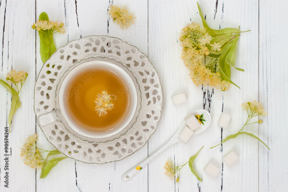 Cup of herbal tea with linden flowers on a old wooden background. Top view Cup of herbal tea with linden flowers on a old wooden background. Top view