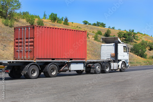 trailer transports container on highway