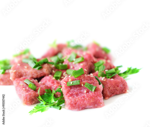 Gnocchi from beet with green onions and parsley on a white background.