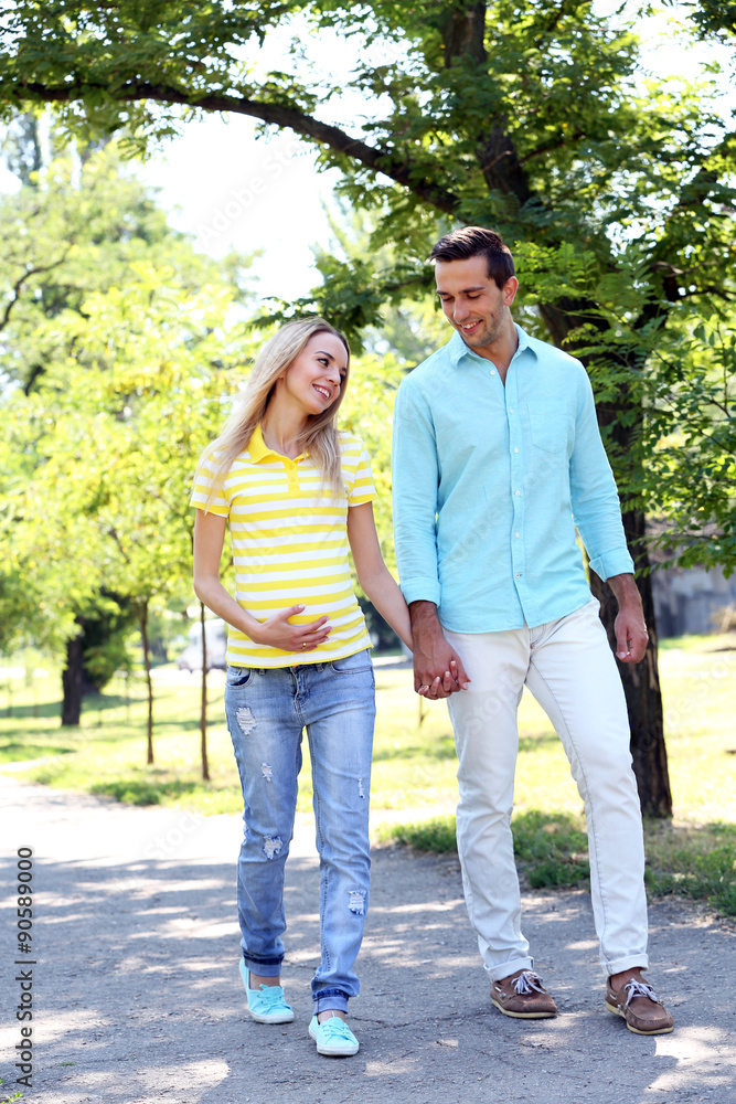 Young pregnant woman with husband walking in park Young pregnant woman with husband walking in park