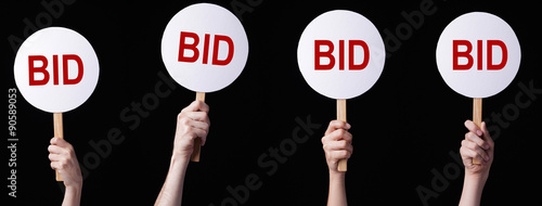 Bidders' hands lifting auction paddles
 photo