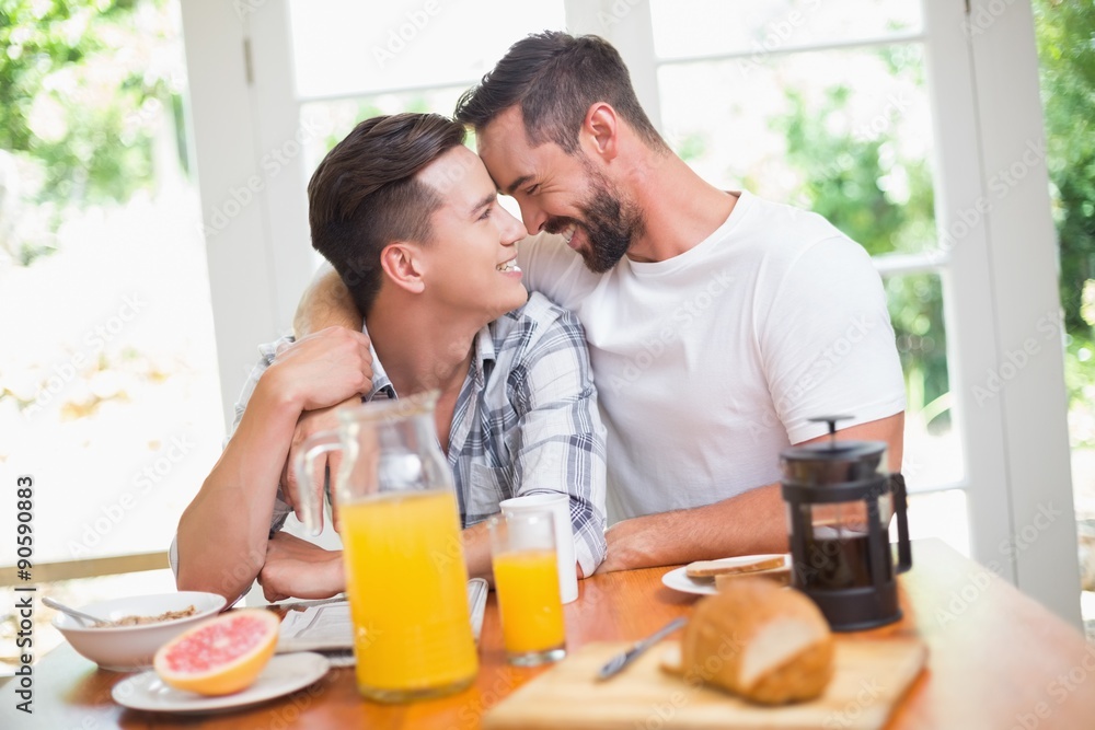 Happy homosexual couple looking at each other during breakfast Happy homosexual couple looking at each other during breakfast
