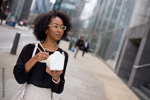 Fényképezés young woman eating a take-away in the city