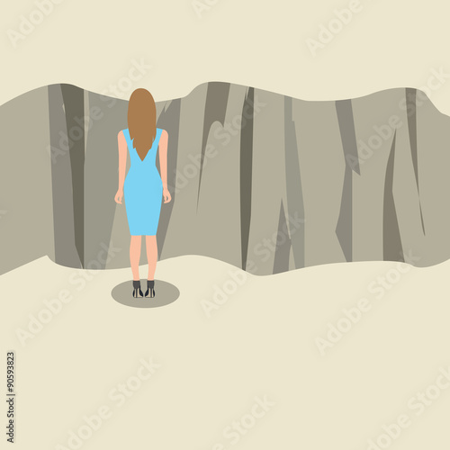 Young woman standing and looking at the edge of a cliff.
