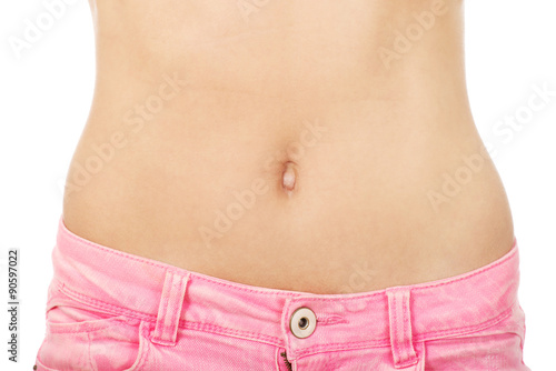 Slim woman wearing jeans showing belly.