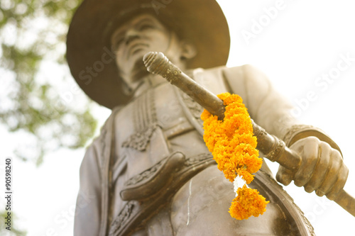 thai king statue with marigold on sword photo