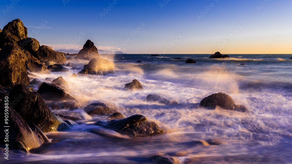 crashing waves at dreamy california beach at sunset