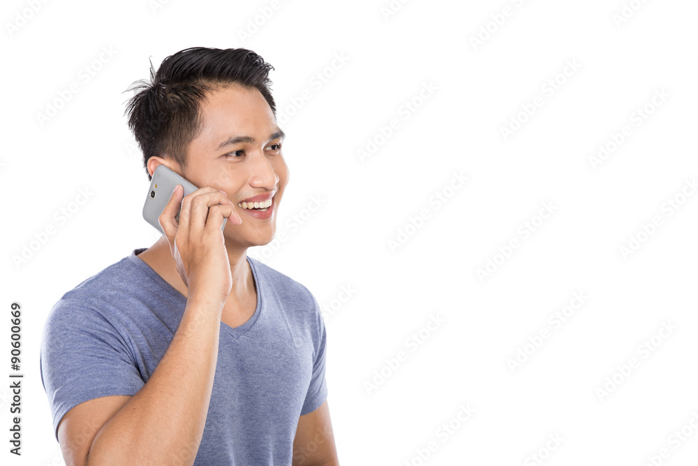 Asian young man talking on a phone isolated on white background Asian young man talking on a phone isolated on white background