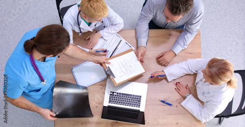 Male and female doctors working on reports in medical office