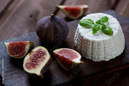 Ricotta with green basil and ripe sliced fig fruits, close-up photo