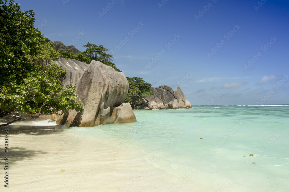 Paradise beach of Seychelles in la Digue island, Anse Source d'Argent. Boulders black granite rocks, turquoise water, white sand and blue sky.