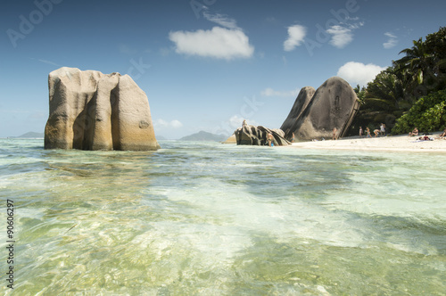 Paradise beach of Seychelles in la Digue island, Anse Source d'Argent. Boulders black granite rocks, tropical vegetation, turquoise water, white sand and blue sky.